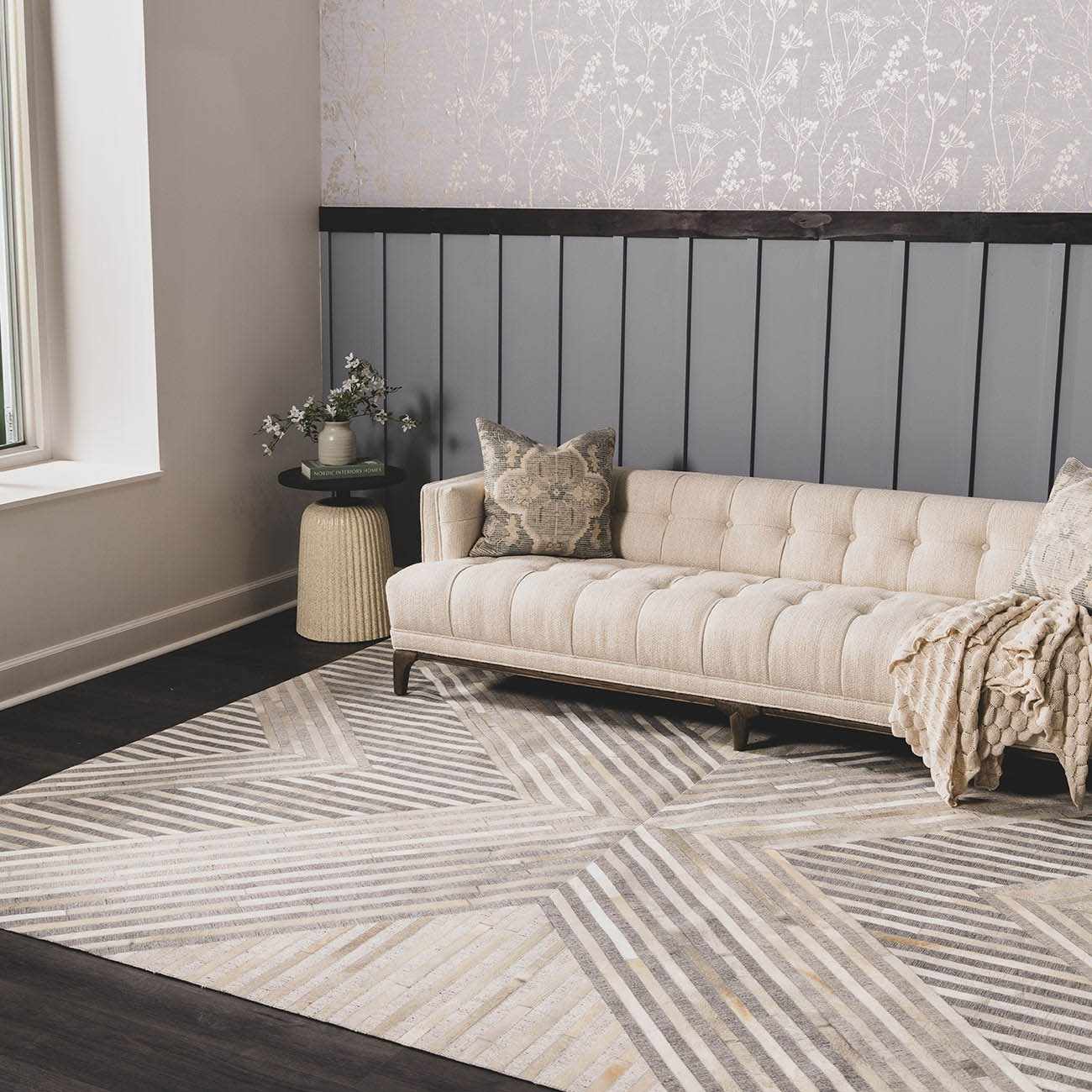 Living room scene with a beige sofa on a geometric Akiye Area Rug in beige, cream, and gray. Roomscene-Rectangle
