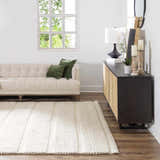 Living room scene with cream Alora Area Rug, beige sofa, and dark wood cabinet. Contemporary style. Roomscene-Rectangle