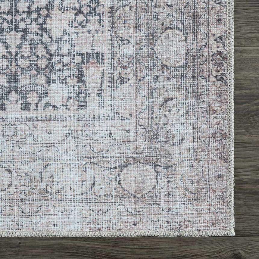 Close-up of the Hedda Boutique Washable Rug. Features a vintage, traditional pattern in dark gray, nutmeg, and light gray tones. Swatch
