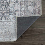 Close-up of the Hedda Boutique Washable Rug showing its dark gray, nutmeg, and gray vintage-style pattern and texture. Fold