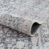 Close-up of the Hedda Boutique Washable Rug. Traditional design in dark gray, gray, and nutmeg colors. Soft chenille texture. Fold