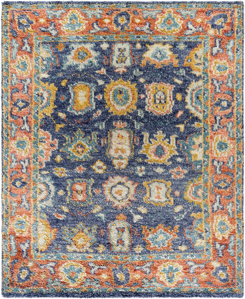 Close-up of the Ankara Premium Wool Area Rug, featuring navy, brick red, and mustard hues in a traditional pattern. Design-Rectangle-810