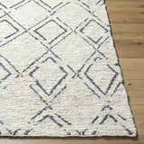 Close-up of Barlig Beige Trellis Jute Carpet showing hand woven texture and geometric black trellis pattern on wood floor. Front