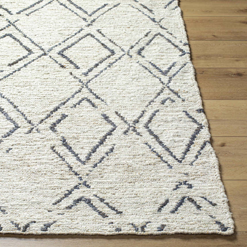 Close-up of Barlig Beige Trellis Jute Carpet showing hand woven texture and geometric black trellis pattern on wood floor. Front