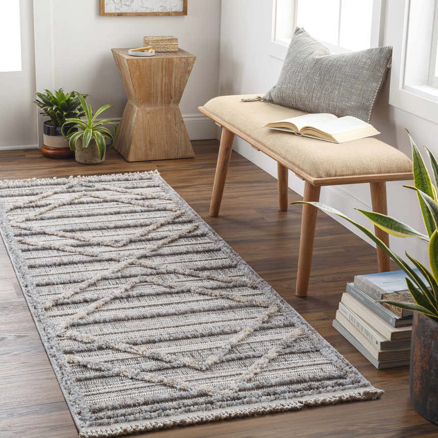 Entryway with Barurao Area Rug runner in charcoal and cream, geometric pattern, bench with book, plants, and wood accents. Roomscene-Runner