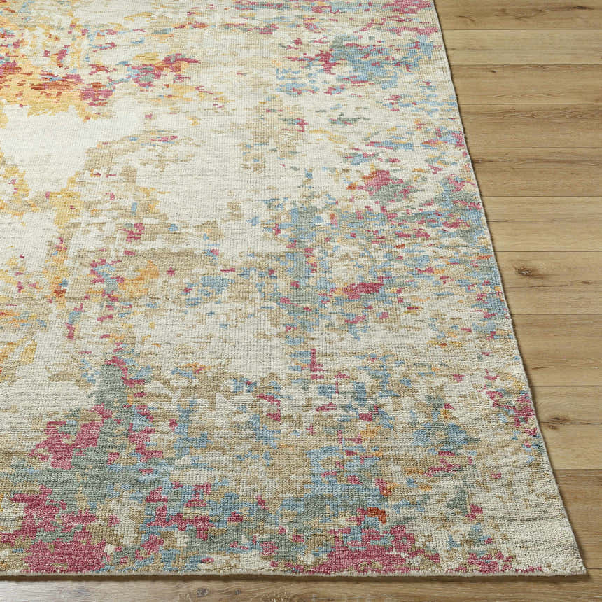 Close up of the hand knotted Bassano Area Rug in brick red, fuchsia, and teal on wood floor. Front