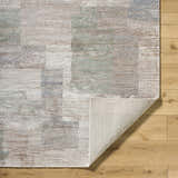 Close-up of the Anaisa Ivory Luxe Thick Area Rug showing its ivory, tan, sage, and gray contemporary block pattern. Fold