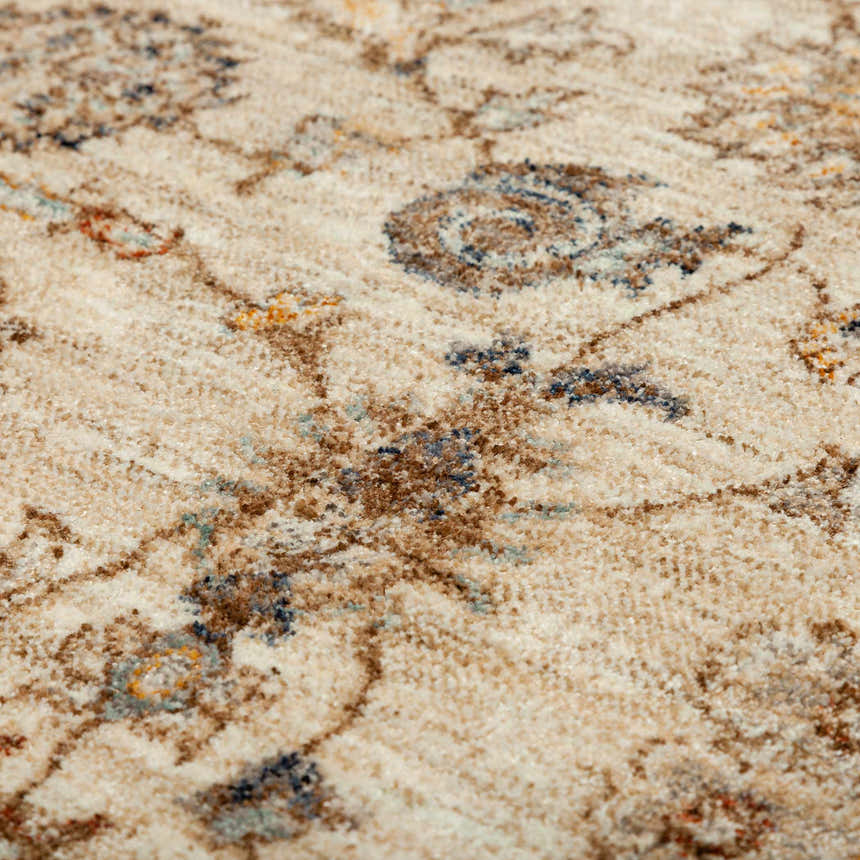 Close-up of the Dalyn Bergama BE5 Ivory Area Rug. Beige rug with chestnut, navy, lt blue, and paprika traditional pattern.