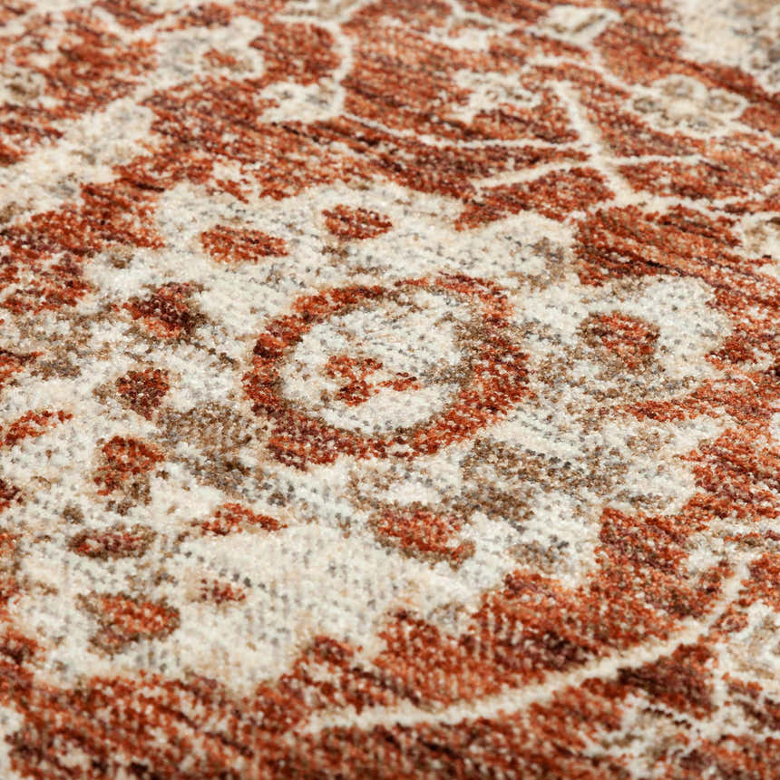 Close-up of the Dalyn Bergama BE6 Paprika area rug. Features a traditional floral pattern in paprika, brown, ivory, and light brown.