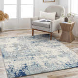 Living room scene with a Beverly Abstract Blue Area Rug, gray chair, and wood side table. Roomscene-Rectangle