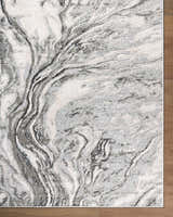 Close up of the Brandi Gray Marble Area Rug, showcasing its beige, gray, and ivory marble-like pattern and texture. Corner