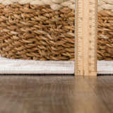 Close-up of the beige Beatus Washable Area Rug showing its geometric pattern and pile height with a ruler. Pile