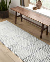 Entryway with a Modern Scandi Architect I Area Rug, wood bench, and plant. Ivory and black rug. Roomscene-Runner