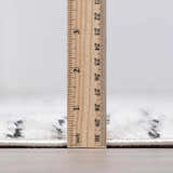 Close-up of the Modern Scandi Architect I Area Rug showing the high pile and thickness with a ruler. Pile