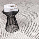 Close-up of Modern Scandi High Pile Architect I Area Rug in ivory and black, with geometric line pattern and black accent table. Styleshot