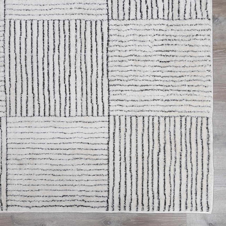 Close up of the Modern Scandi Architect I Area Rug. Ivory rug with a black geometric pattern of lines and squares. Swatch