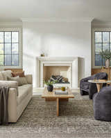 Living room scene with beige sofa, gray chairs, and Collins Avenue GACA-2302 area rug in beige, red, and green. Roomscene-Rectangle