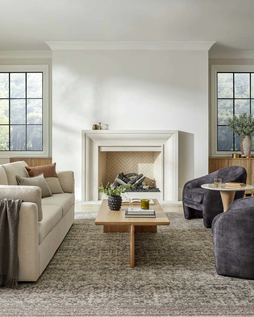 Living room scene with beige sofa, gray chairs, and Collins Avenue GACA-2302 area rug in beige, red, and green. Roomscene-Rectangle