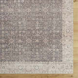 Close-up of the Spokane Machine Woven rug. Charcoal, ivory, and tan floral pattern with a traditional border design. Corner