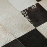 Close up of the Dalyn Luxury Bozeman BM10 Black Washable Area Rug. Beige, black, and chestnut colored patchwork design.