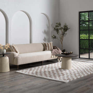 Living room scene with a neutral sofa and the Barbate White Area Rug, a checkered shag rug in white, gray, and brown. Roomscene-Rectangle