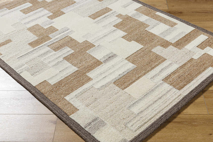 Close-up of the hand-tufted Berker Area Rug. Contemporary geometric design in beige, charcoal, cream, light gray, and taupe wool. Corner