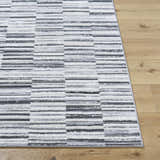 Close-up of Bronco Broken Striped Area Rug. Contemporary design with black, charcoal, gray, and ivory stripes. Front