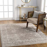 Living room scene with a brown Bolitoc Area Rug, wood floors, cane chair, and gold accent tables. Roomscene-Rectangle