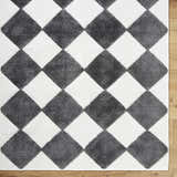 Close-up of the Bosley Black Washable Area Rug. Features a black and off-white diamond pattern with a textured pile. Corner