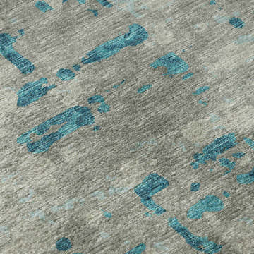 Close-up of Dalyn Brisbane BR5 Teal Washable Area Rug. Gray rug with abstract teal shapes and a textured, casual design.