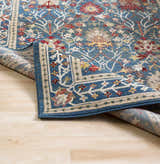 Close-up of Livabliss Crafty Surya CRT-2308 area rug. The machine woven rug has a blue, burgundy, and tan traditional pattern. Fold