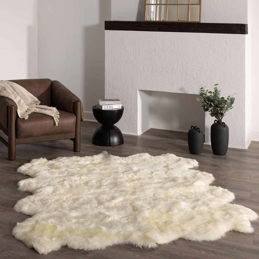 Living room with a Premium White Soft Sheepskin Rug, brown leather chair, and fireplace. Roomscene-Custom