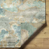 Close-up of Briceville Premium Area Rug showing ivory, green, blue, peach, and wheat abstract pattern and hand-knotted construction. Fold