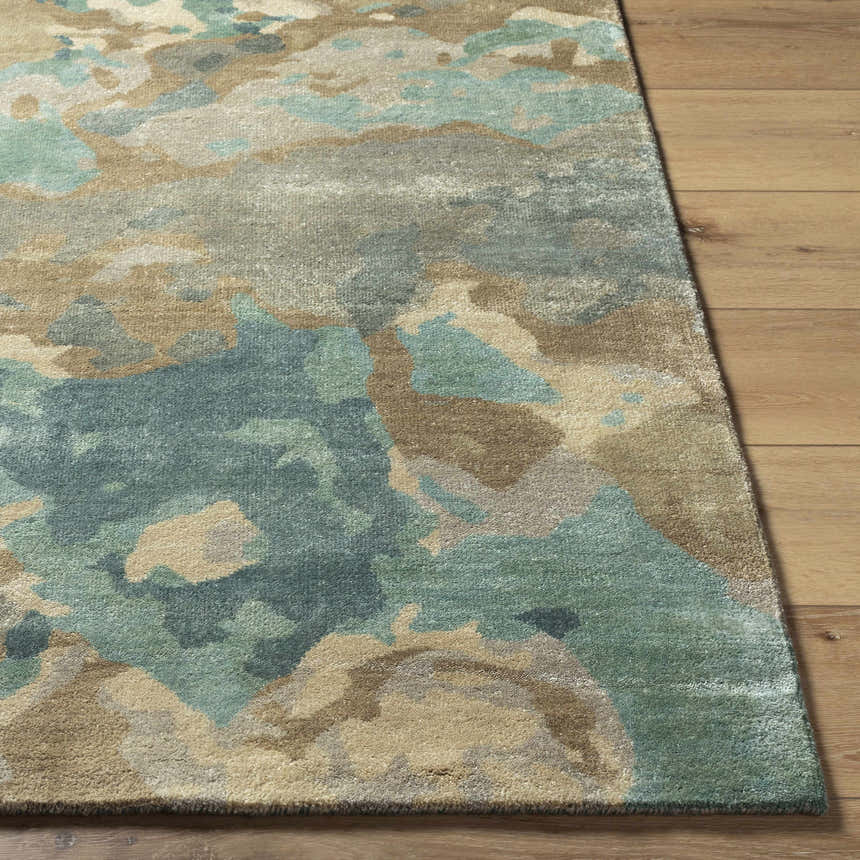 Close up of Briceville Premium Area Rug showing ivory, green, blue, peach, and wheat abstract pattern and wool texture. Front