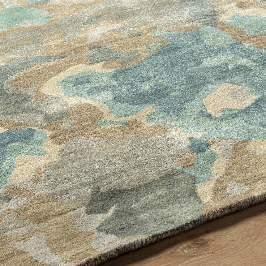 Close-up of the Briceville Premium Area Rug showing its ivory, green, blue, peach, and wheat abstract design. Pile