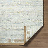 Close-up of the hand-woven Andrey Dark Beige Area Rug showing charcoal, light brown, and medium brown tones. Wool texture visible. Fold