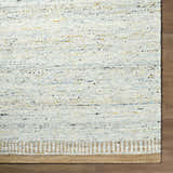 Close-up of the hand-woven Andrey Dark Beige Area Rug showing charcoal, light brown, and medium brown wool texture. Corner