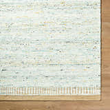Close-up of the hand woven Andrey Dark Beige Area Rug showing texture, charcoal, light and medium brown colors. Corner