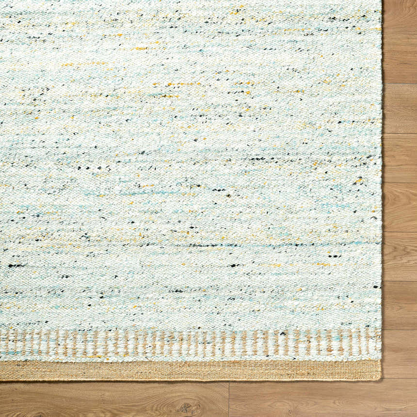 Close-up of the hand woven Andrey Dark Beige Area Rug showing texture, charcoal, light and medium brown colors. Corner