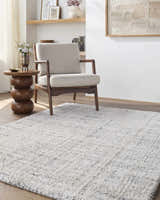 Living room scene with a light gray armchair and Yidia White Solid Area Rug. Roomscene-Rectangle