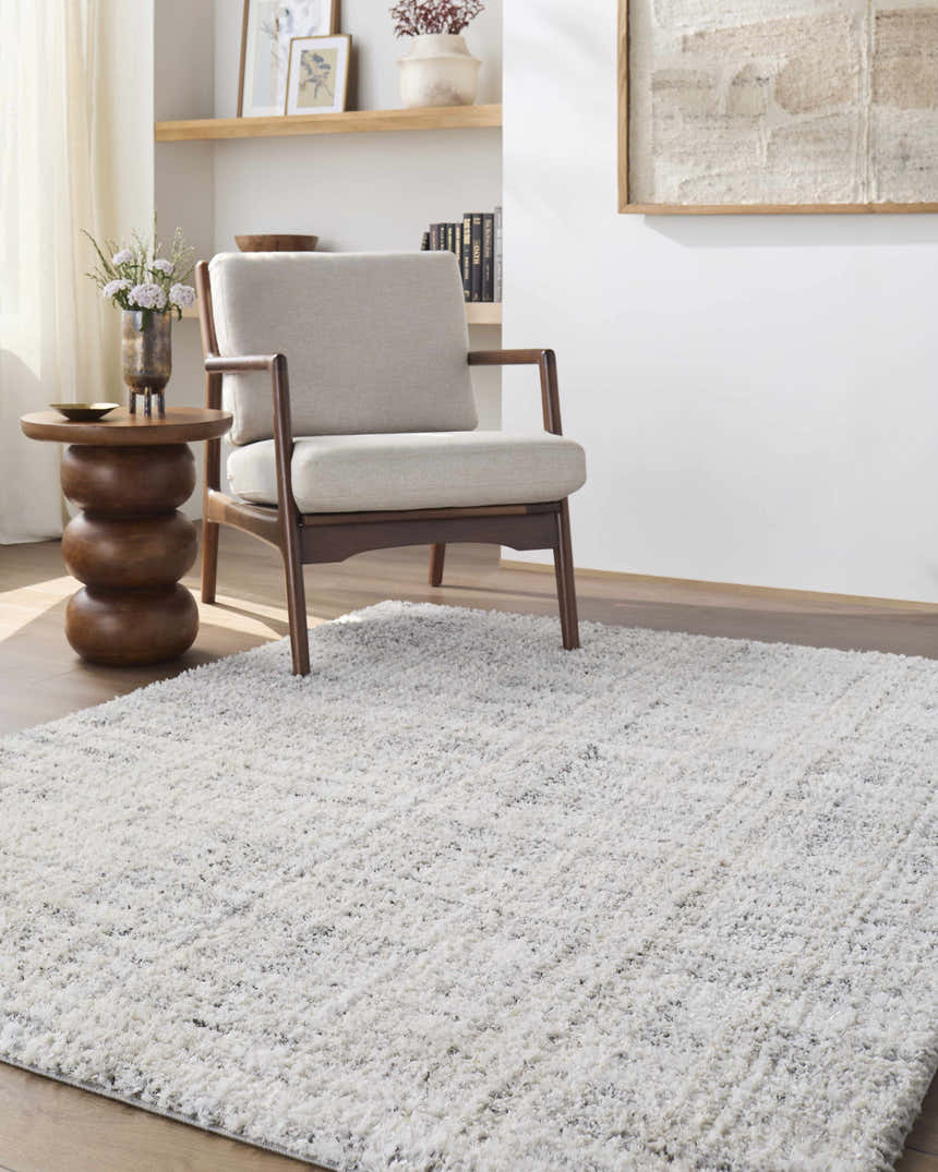 Living room scene with a light gray armchair and Yidia White Solid Area Rug. Roomscene-Rectangle