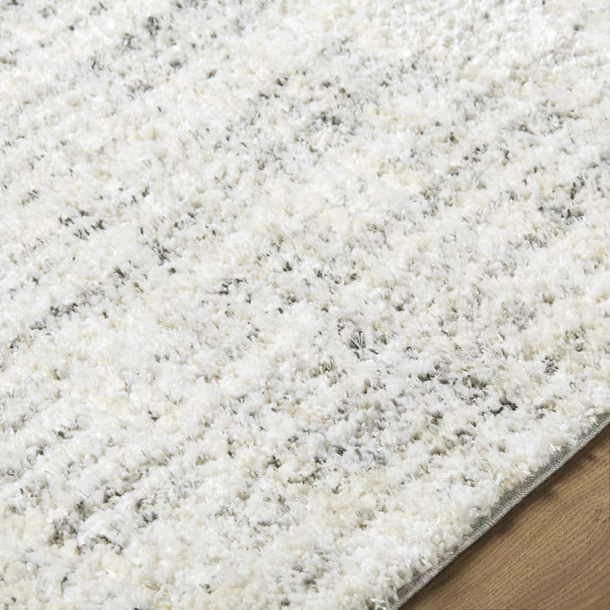 Close up of the textured Yidia White Solid Area Rug with off white, light gray, and black tones. Texture