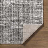 Close up of the Reyoa Light Gray rug showing the polyester texture and machine woven construction. Fold