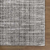 Close-up of the Reyoa Light Gray rug showing its plush polyester texture and subtle geometric pattern on a wood floor. Corner