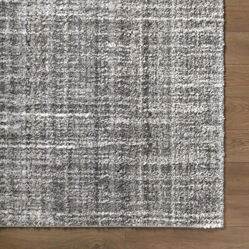 Close-up of the Reyoa Light Gray rug showing its plush polyester texture and subtle geometric pattern on a wood floor. Corner