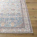 Close-up of the Bahram Vintage Flat Pile Washable Rug; teal, cream, and dark red traditional pattern on a wood floor. Front