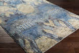 Close-up of Bushong Jute Carpet in blue, brown, and white, showcasing Southwestern style and hand-knotted texture on wood floor. Corner