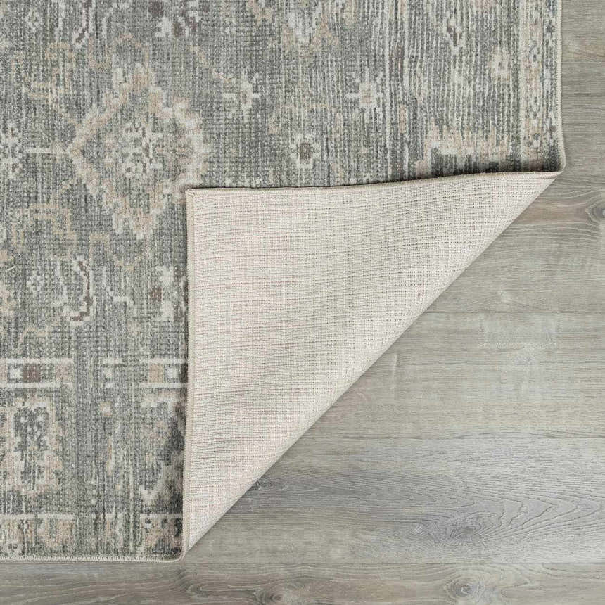 Close-up of the Collins Avenue I Vintage Oushak Area Rug showing its gray, beige, and brown tones and machine-woven texture. Fold