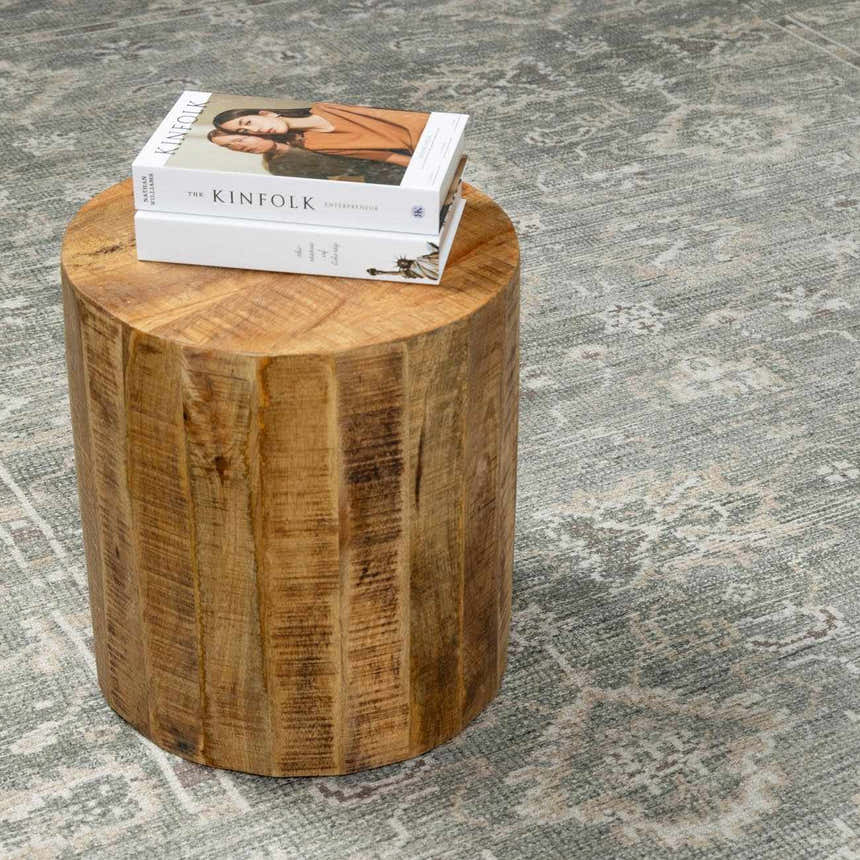 Close-up of the beige and gray vintage pattern on the Collins Avenue I Oushak Area Rug with a wood side table. Styleshot