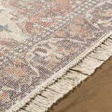 Close-up of the hand-loomed Bohdan Terracotta Area Rug, showing its farmhouse style, fringe, and charcoal, ivory, and terracotta colors. Texture